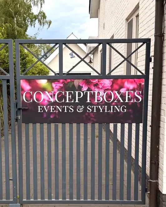 De grijze toegangspoort met het bord Conceptboxes Events & Styling