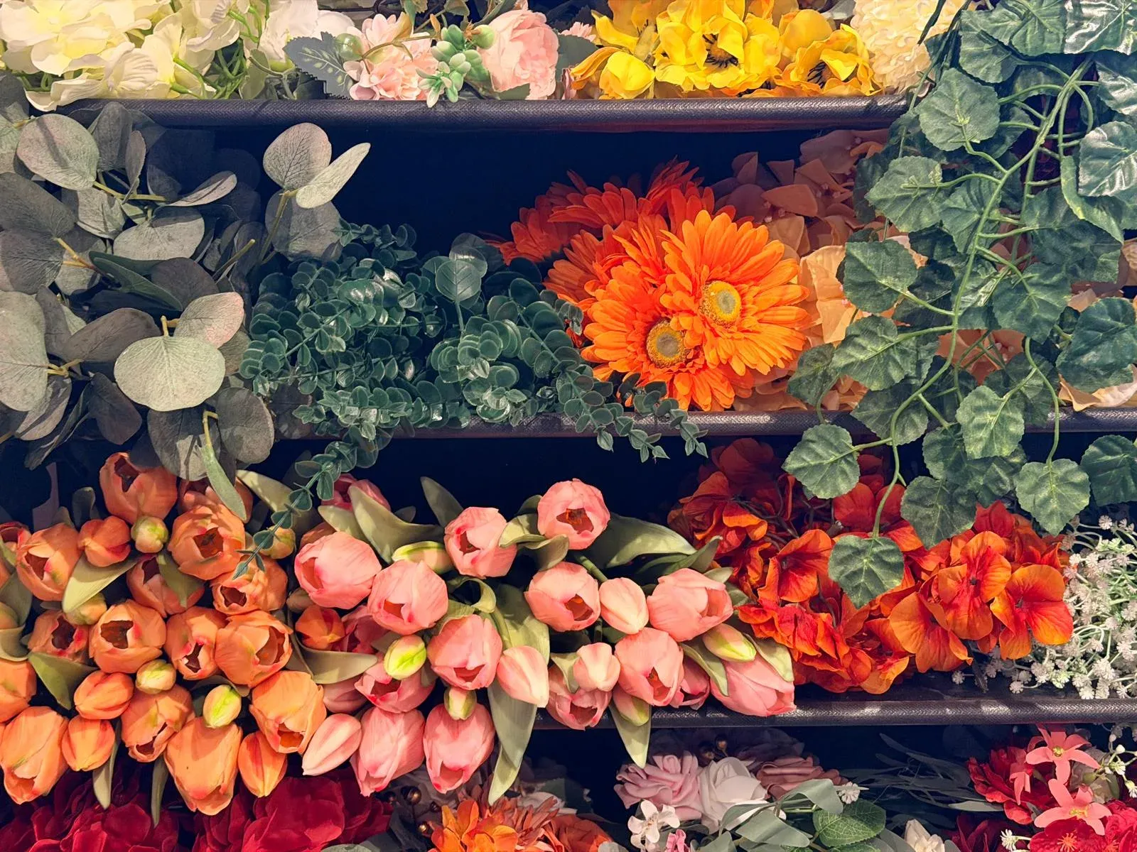 Het rek met kunstbloemen in het atelier